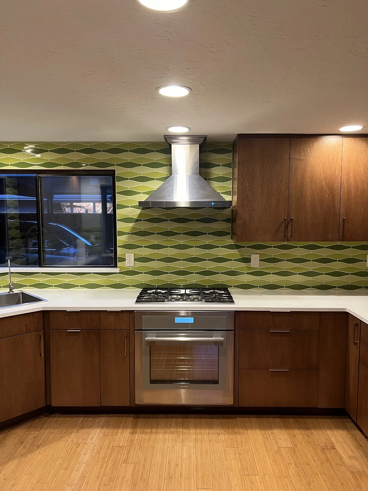 Mid-century Bellingham kitchen with wood cabinetry, quartz waterfall peninsula and green tile backsplash in Bellingham, WA — Living By Design (2)