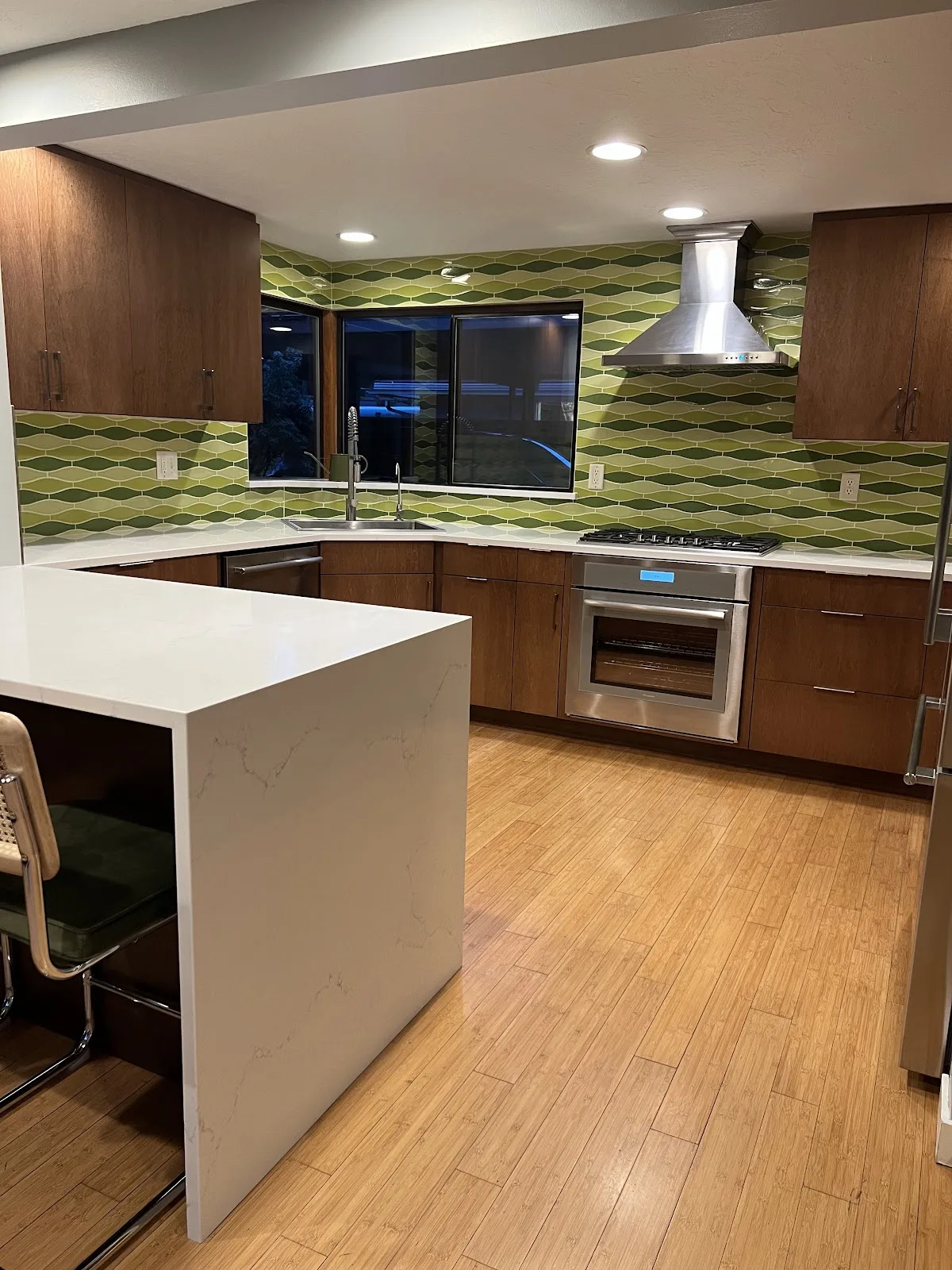 Mid-century Bellingham kitchen with wood cabinetry, quartz waterfall peninsula and green tile backsplash in Bellingham, WA — Living By Design (3)