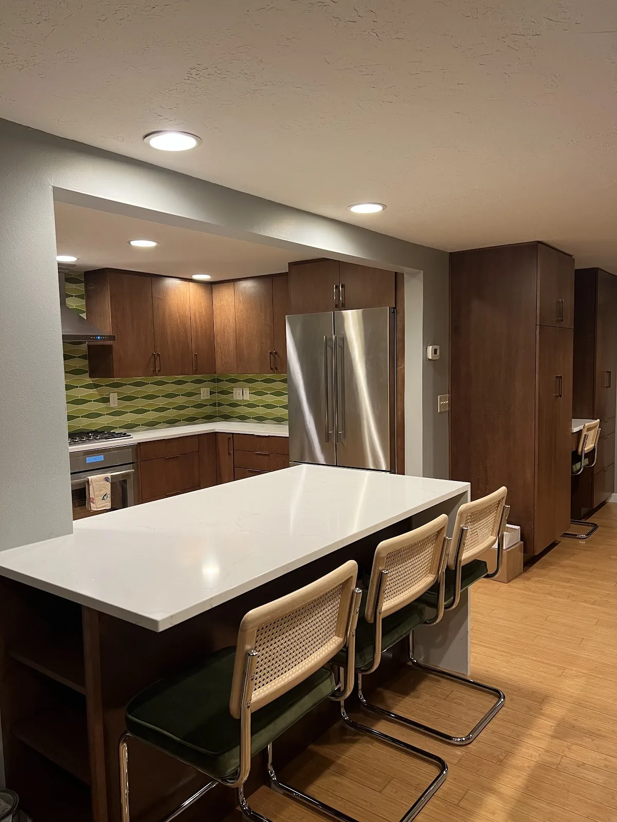 Mid-century Bellingham kitchen with wood cabinetry, quartz waterfall peninsula and green tile backsplash in Bellingham, WA — Living By Design (6)