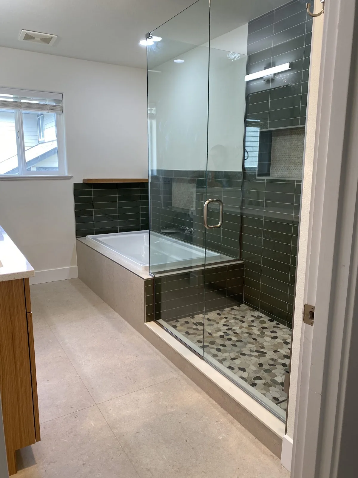 Bellingham bathroom with green and navy tile, wood vanity and freestanding tub in Bellingham, WA — Living By Design