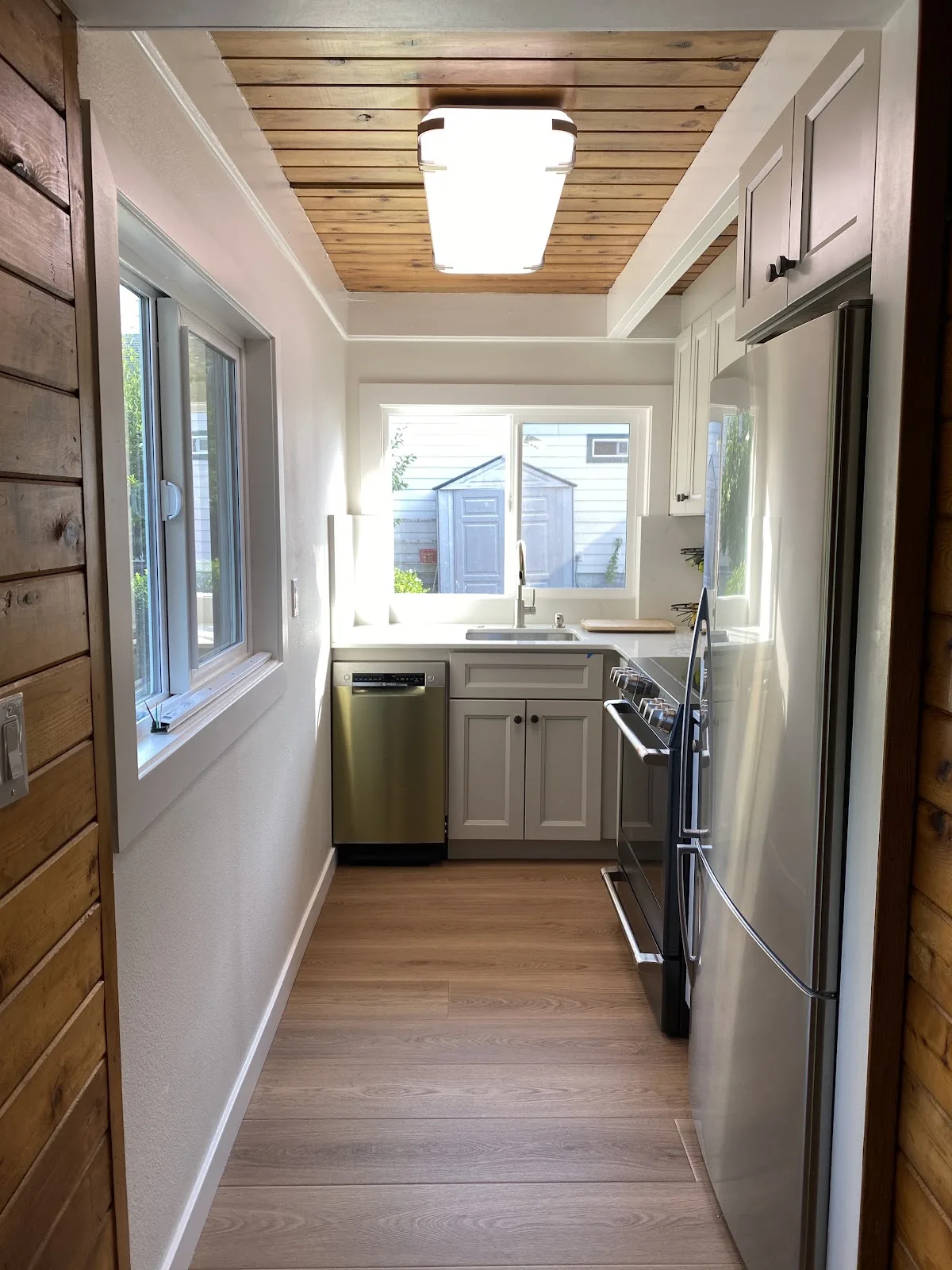 Blaine kitchen with white shaker cabinetry, quartz counters and wood-plank ceiling in Blaine, WA — Living By Design