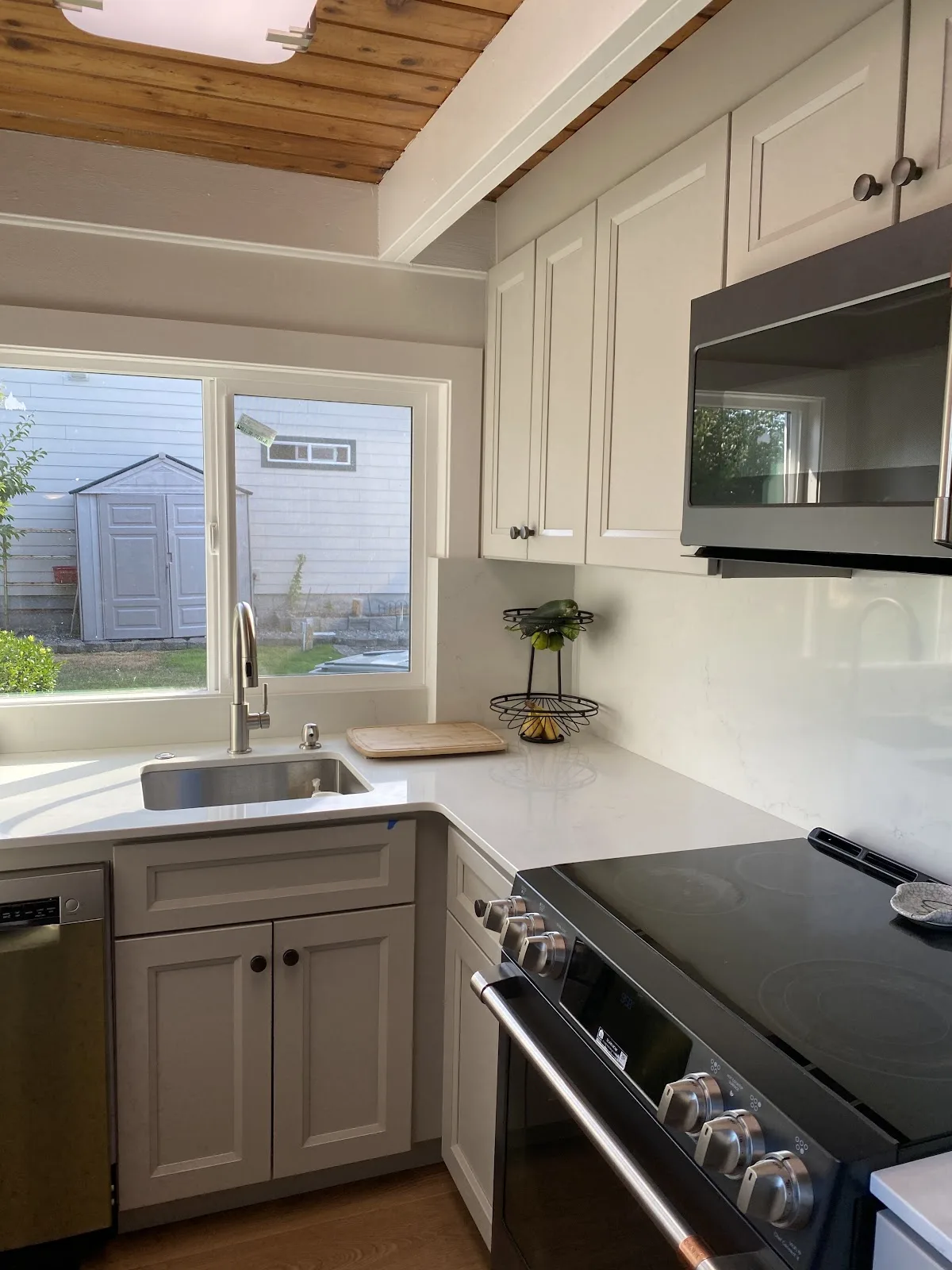 Blaine kitchen with white shaker cabinetry, quartz counters and wood-plank ceiling in Blaine, WA — Living By Design (2)