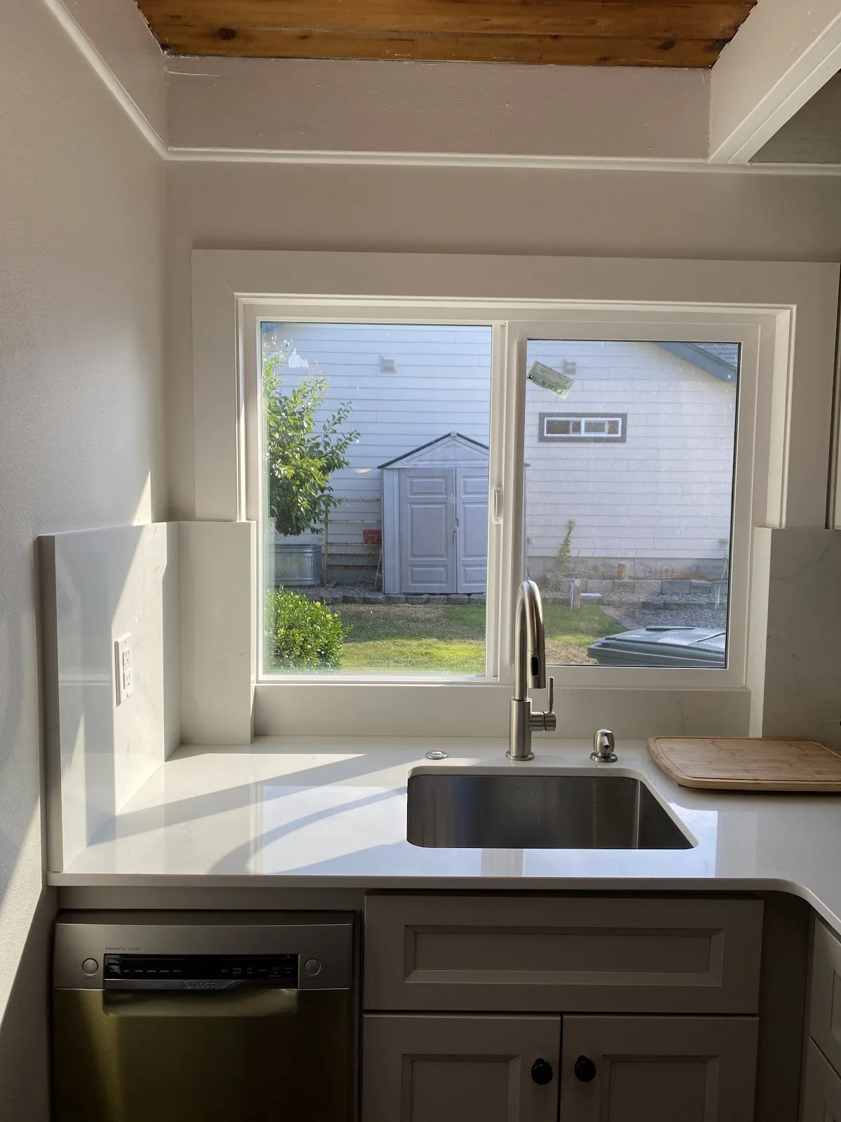 Blaine kitchen with white shaker cabinetry, quartz counters and wood-plank ceiling in Blaine, WA — Living By Design (3)