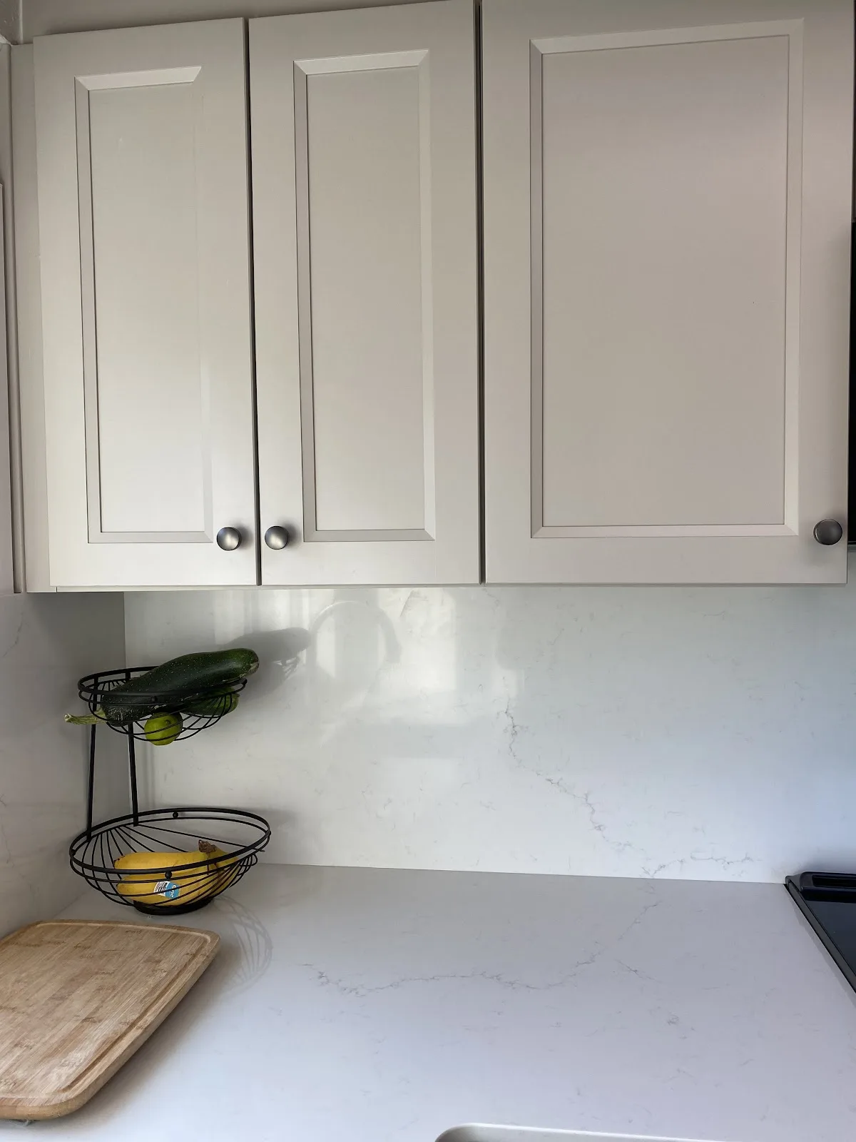 Blaine kitchen with white shaker cabinetry, quartz counters and wood-plank ceiling in Blaine, WA — Living By Design (4)