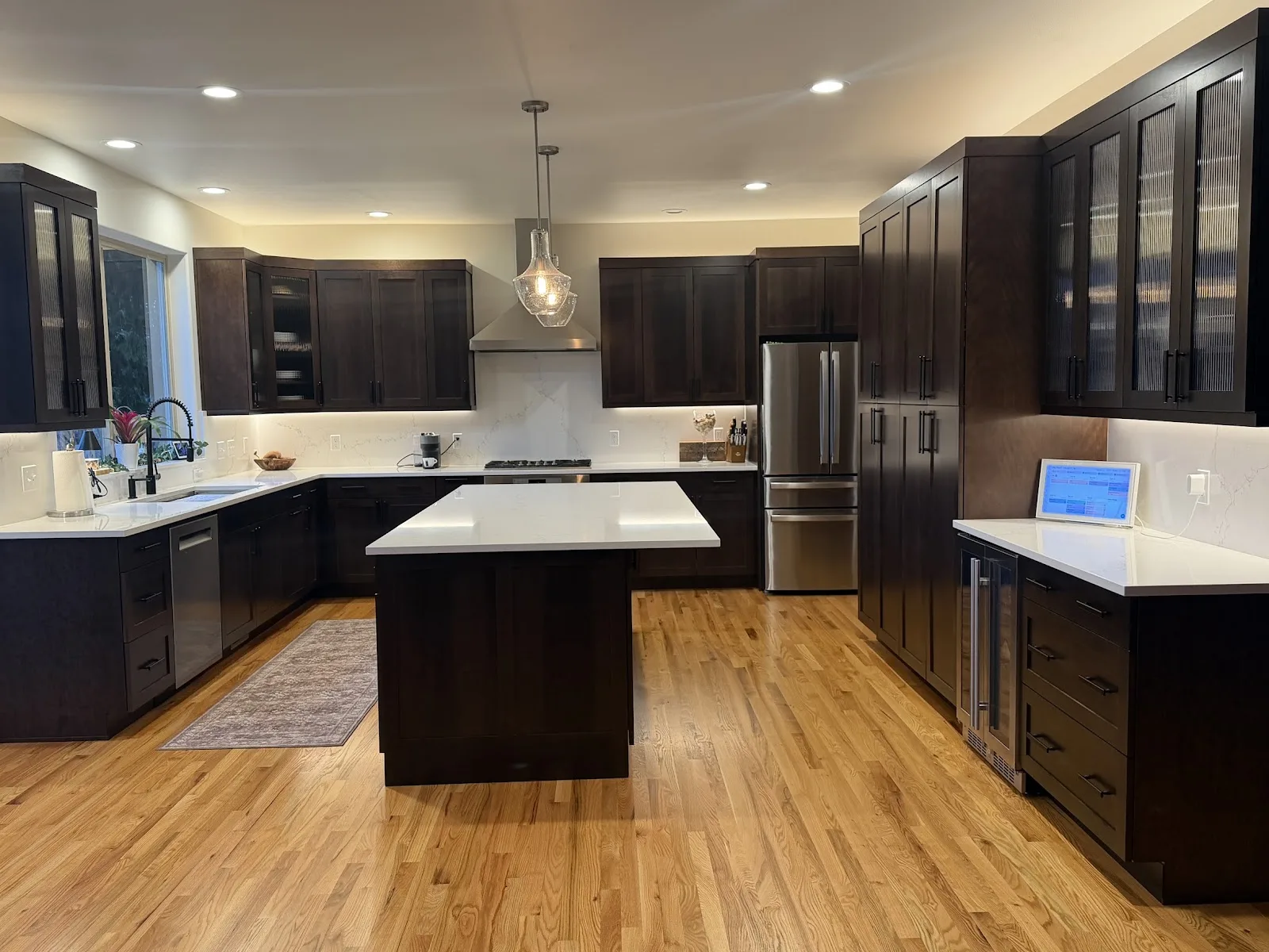 Cherry kitchen with quartz island and hardwood floors in Bellingham, WA — Living By Design