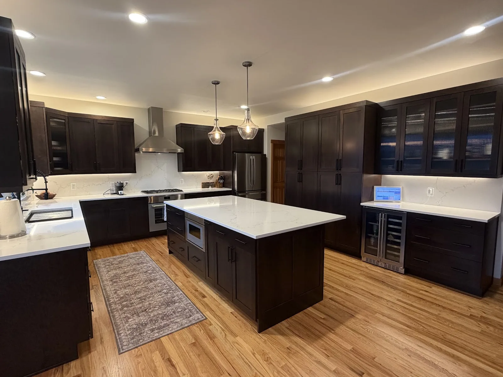 Cherry kitchen with quartz island and hardwood floors in Bellingham, WA — Living By Design (2)