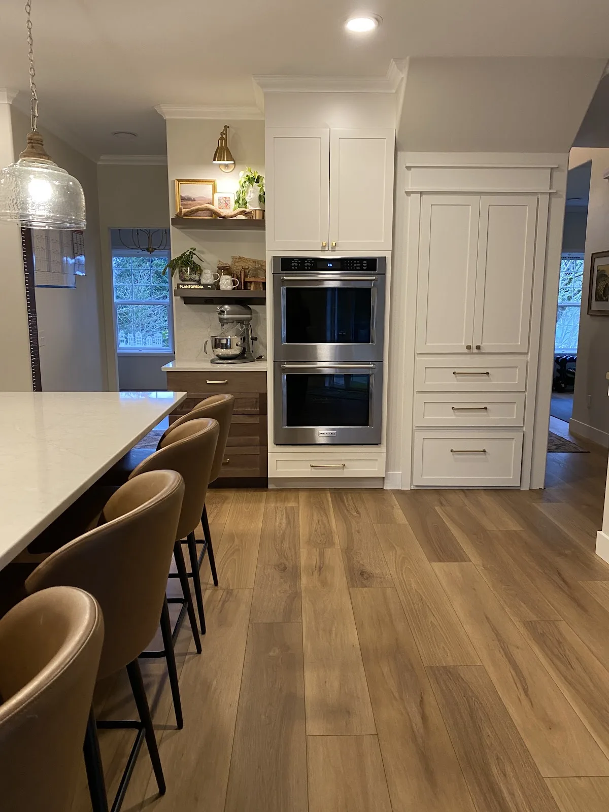 Bright white kitchen with quartz countertops and wood-look flooring in Bellingham, WA — Living By Design (2)
