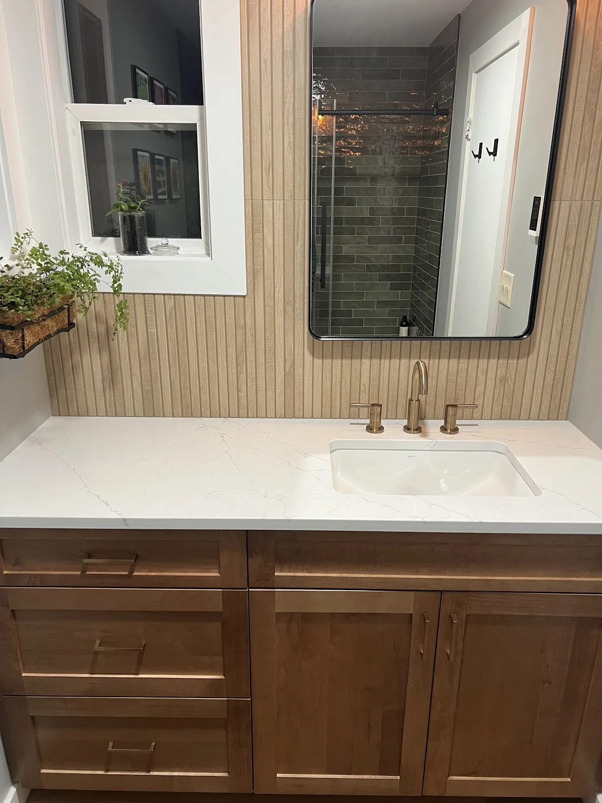 Bathroom with wood vanity and a tiled walk-in glass shower in Bellingham, WA — Living By Design