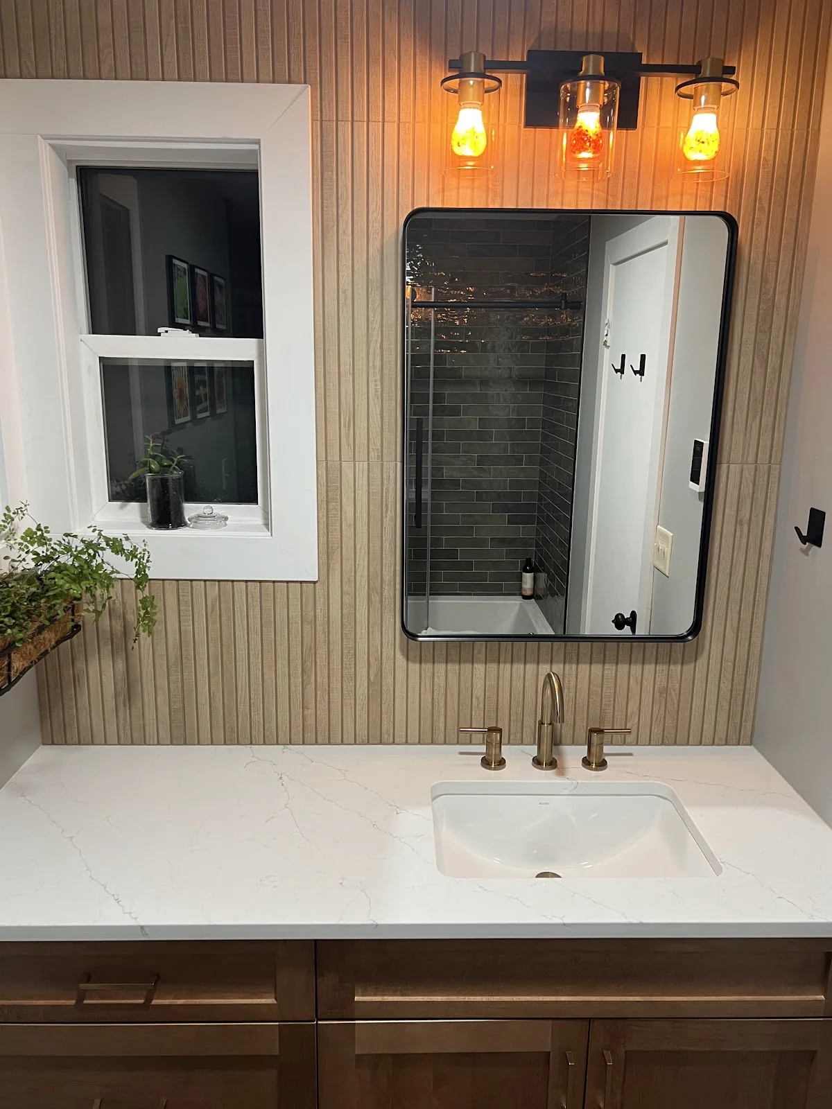 Bathroom with wood vanity and a tiled walk-in glass shower in Bellingham, WA — Living By Design (2)