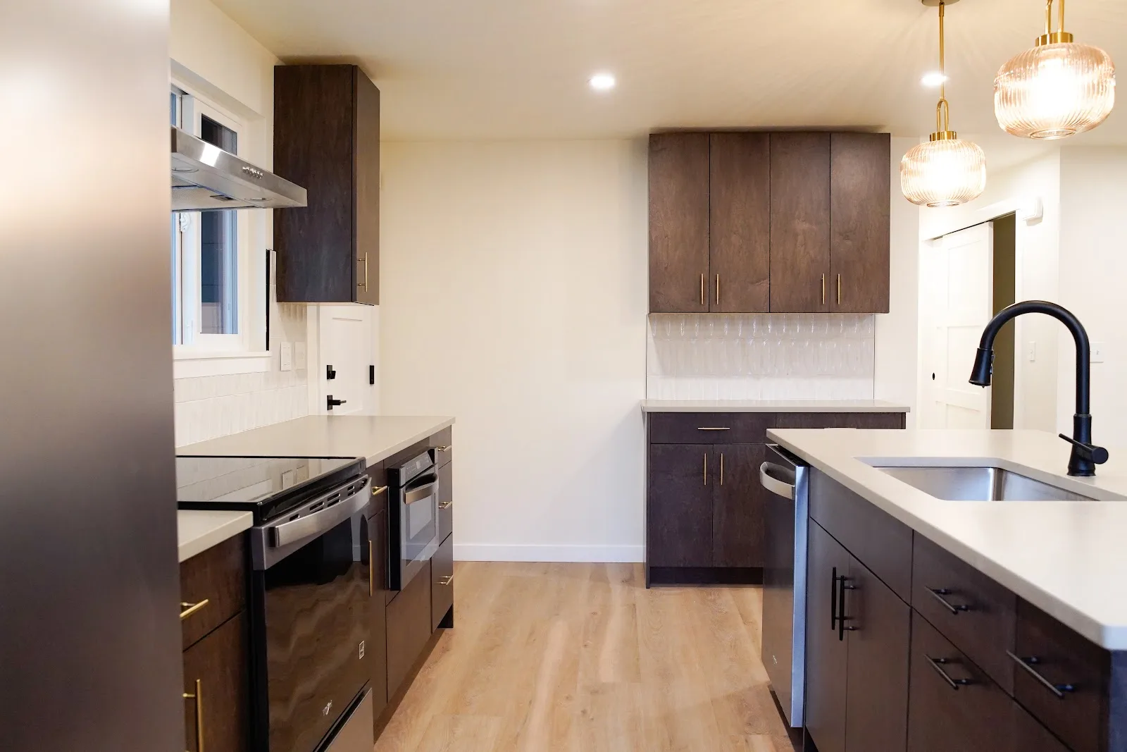 Kitchen and bath remodel with stained cabinetry, quartz island and a tiled fireplace wall in Bellingham, WA — Living By Design