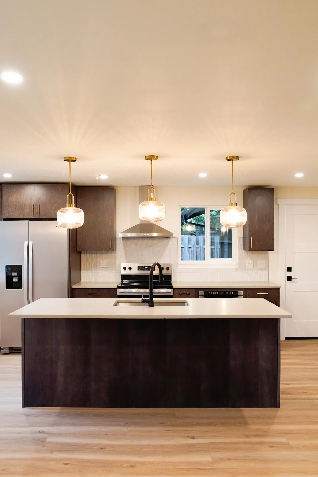 Kitchen and bath remodel with stained cabinetry, quartz island and a tiled fireplace wall in Bellingham, WA — Living By Design (8)