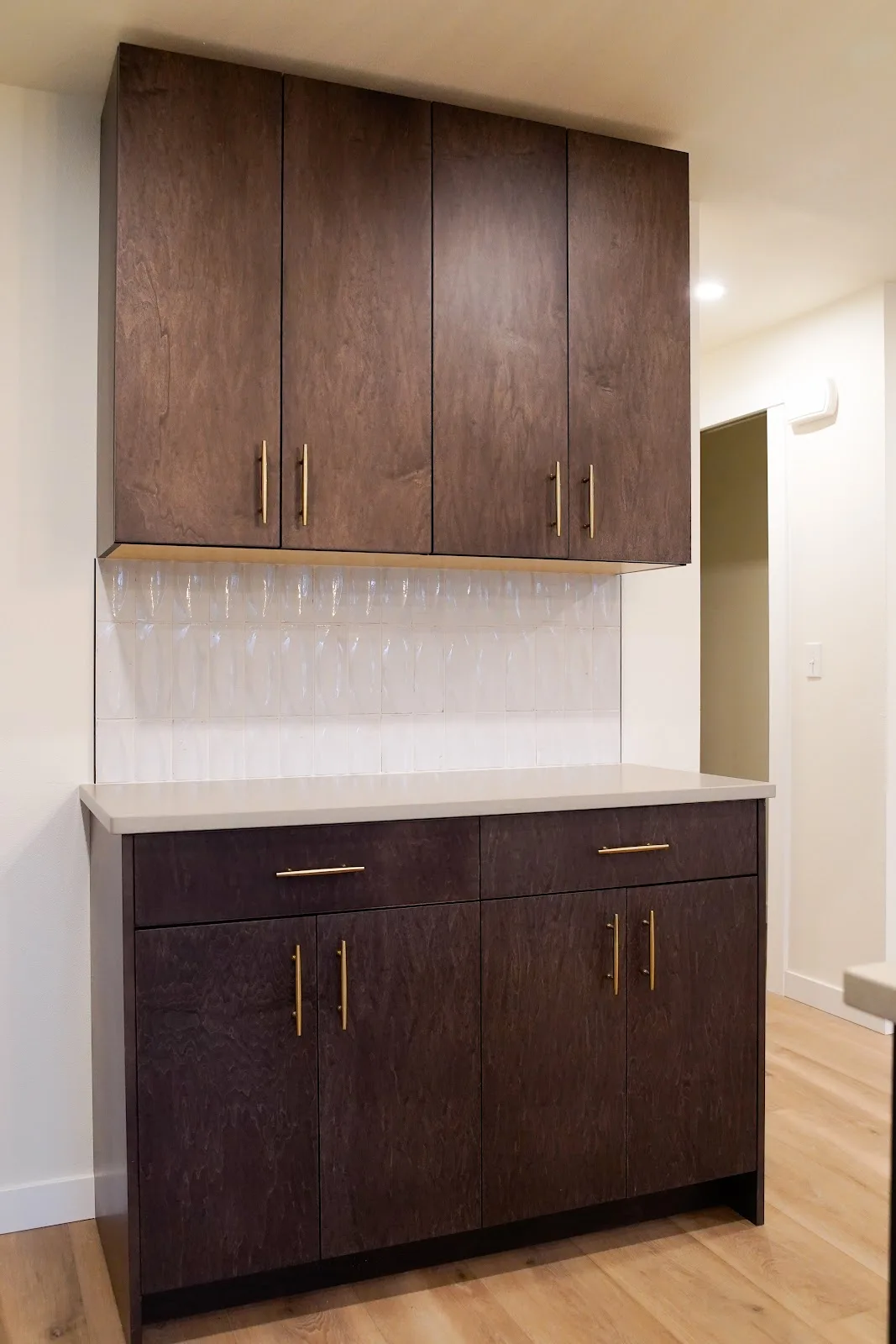 Kitchen and bath remodel with stained cabinetry, quartz island and a tiled fireplace wall in Bellingham, WA — Living By Design (9)