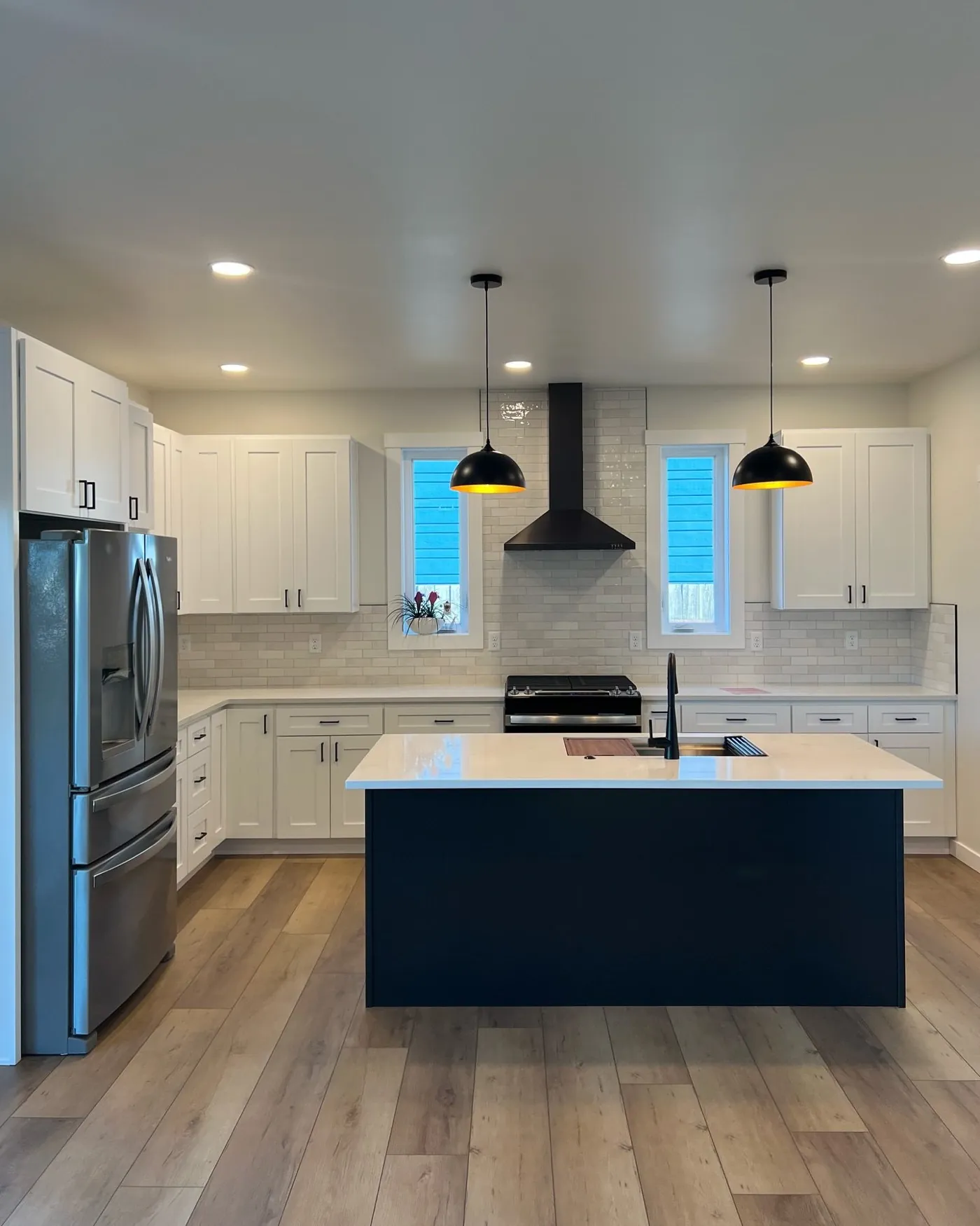 Completed white kitchen remodel with navy island by Living By Design in Bellingham, WA